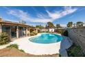 Backyard featuring a pristine in-ground pool surrounded by a concrete patio and mature trees at 4476 Oakhill Cir, Las Vegas, NV 89121