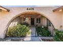 Close up of the front entrance with a decorative gate and lush greenery at 4476 Oakhill Cir, Las Vegas, NV 89121