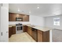 Well-lit kitchen features stainless steel appliances, granite counters, and dark wood cabinets at 4561 Woolcomber St, Las Vegas, NV 89115