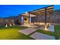 Backyard patio area features a pergola with seating, outdoor lighting, and a TV for entertainment at 5231 Iron River Ct, Las Vegas, NV 89135