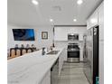 Spacious kitchen featuring stainless steel appliances, white cabinetry, a large center island, and sleek countertops at 6144 Rathbone St, Las Vegas, NV 89166