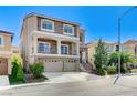 Inviting two-story house with stone accents, balcony, three-car garage, and well-maintained lawn at 6773 Goose Watch Ct, Las Vegas, NV 89139