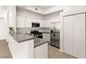 Modern kitchen with stainless steel appliances, white cabinets, and gray countertops at 700 Carnegie St # 3214, Henderson, NV 89052