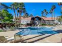 Sparkling community pool surrounded by palm trees and comfortable lounge chairs at 700 Carnegie St # 3214, Henderson, NV 89052