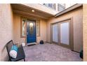Inviting front porch featuring a blue door, tiled flooring, and seating area at 8224 Opal Falls St, North Las Vegas, NV 89085