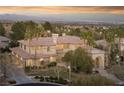 Expansive property showcasing a luxurious home with a tile roof and lush landscaping and city views at 9904 Moonridge Ct, Las Vegas, NV 89134