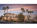Beautiful home with a grand entrance, lush landscaping, and towering palm trees lining the front yard at 9904 Moonridge Ct, Las Vegas, NV 89134