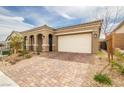 Attractive single-story home with a brick driveway, desert landscaping, and a two-car garage at 10943 Doresta Ave, Las Vegas, NV 89166