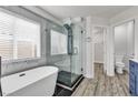 Bathroom showcasing a modern tub and shower with glass doors at 11016 Meadow Leaf Ave, Las Vegas, NV 89144
