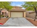 Two-car garage and driveway with desert landscaping at 11016 Meadow Leaf Ave, Las Vegas, NV 89144