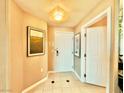 Hallway with neutral walls and floors with artwork leads to the front door at 135 E Harmon Ave # 2916, Las Vegas, NV 89109