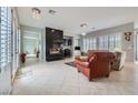 Bright and airy living room with fireplace, tile flooring, and plantation shutters at 2116 Burtonsville Dr, Henderson, NV 89044