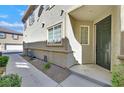 Home's inviting front entrance features a covered porch, landscaped walkway, and dark green door at 3920 Sweet Pine St # 102, Las Vegas, NV 89108