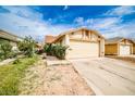 Beige single-story home featuring a two-car garage and a concrete driveway with green front lawn at 4438 Faberge Ave, Las Vegas, NV 89115