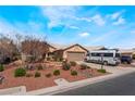 Exterior shot of single-story home with neutral stucco, tile roof, desert landscaping, and an attached garage at 5433 Honey Mesquite Ln, Las Vegas, NV 89130