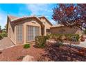 Exterior view of a home with desert landscaping, trees, and neutral stucco at 5433 Honey Mesquite Ln, Las Vegas, NV 89130