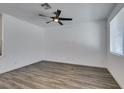 Bright living room with wood-look flooring, ceiling fan, and natural light from the window at 5730 Sky Pointe Dr # 165, Las Vegas, NV 89130