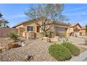 Charming home exterior with rock landscaping, desert plants, and a two car garage at 6022 Quintillion Ave, Las Vegas, NV 89122