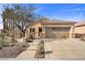 Charming exterior of home with desert landscaping, stone accents, and large driveway at 6022 Quintillion Ave, Las Vegas, NV 89122