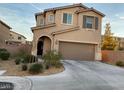 Front exterior of a tan two-story home with desert landscaping and an attached two-car garage at 6563 Pine Hall Ave, Las Vegas, NV 89122