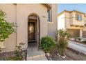 Close up view of the front door, complemented by manicured shrubs and an arched entryway at 6653 Ashley House Ct, Las Vegas, NV 89139