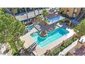 Aerial view of a sparkling pool and jacuzzi surrounded by lush landscaping and shaded lounging areas at 7950 W Flamingo Rd # 1044, Las Vegas, NV 89147