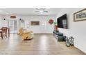 Bright living room featuring wood-look tile floors, a ceiling fan, and a neutral color palette at 8117 Discovery Point St, Las Vegas, NV 89139