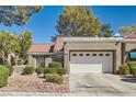 Attractive single-story home with a red tile roof and a two-car garage with decorative windows at 8628 Desert Holly Dr, Las Vegas, NV 89134
