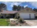 Inviting home features a two-car garage, desert landscaping, and tile roof at 8641 Surtidor Dr, Las Vegas, NV 89117