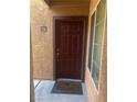 A dark red front door with a Welcome mat invites you into the home at 9325 W Desert Inn Rd # 174, Las Vegas, NV 89117