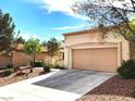 View of the garage and driveway of a charming single-story home in a residential neighborhood at 11031 Mission Lakes Ave, Las Vegas, NV 89134