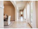 Bright hallway with stone floors, arched doorway and beautiful French doors and plenty of natural light at 12097 Oakland Hills Dr, Las Vegas, NV 89141