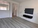 Living room with light vinyl floors and a modern wall-mounted television console at 1820 Peridot Point St, Las Vegas, NV 89106