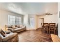 Inviting living room with hardwood floors, large windows, and comfortable seating adjacent to the dining area at 1830 N Pecos Rd # 137, Las Vegas, NV 89115