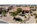 Aerial view of a tan house with a tile roof, desert landscaping, and a putting green in the front yard at 2606 Crested Butte St, Henderson, NV 89052