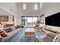 Open-concept living room featuring high ceilings, neutral tones, and large sliding glass doors to the backyard at 2669 Via Monet, Henderson, NV 89044