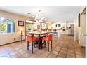 Dining room showcasing a modern chandelier and terracotta tile flooring, connecting to the kitchen at 4360 Flandes St, Las Vegas, NV 89121