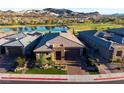 Expansive aerial view of a home with lush landscaping, a serene lake and mountain views at 47 Reflection Bay Dr, Henderson, NV 89011