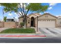 Inviting single-level home with a two-car garage and a front yard featuring lush green grass and mature tree at 5107 Morning Splash Ave, Las Vegas, NV 89131