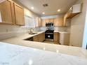 Functional kitchen featuring light wood cabinets, modern appliances, and ample counter space at 5384 Hanging Tree Ln, Las Vegas, NV 89118
