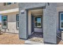 Inviting townhome entrance showcasing a covered entryway with textured walls and tiled flooring at 6157 Aster Garden St # 153, North Las Vegas, NV 89081