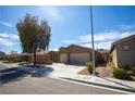 Attractive single-story house with a two-car garage, landscaping and a shade tree at 703 Flaming Cliffs Ct, Henderson, NV 89014