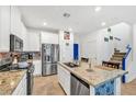 Modern kitchen with stainless steel appliances, granite countertops, and stylish blue accents on the stairs at 7364 N Decatur Blvd # 4, Las Vegas, NV 89131
