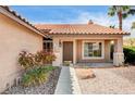Close-up of a charming front entrance with a well-kept garden and tile roof detail at 8851 Quintane Ln, Las Vegas, NV 89123