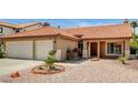 Inviting front yard with desert landscaping leading to a well-maintained home with a tile roof at 8851 Quintane Ln, Las Vegas, NV 89123