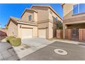 Tan two-story home featuring a two-car garage and charming desert landscaping at 9494 Alma Ridge Ave, Las Vegas, NV 89178
