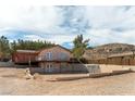 Two story house features a stone facade, a back yard patio, and desert landscaping at 9865 Penny Ln, Las Vegas, NV 89178