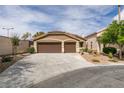 Home exterior featuring a three car garage, desert landscaping, and a tile roof at 10452 Niagara Falls Ln, Las Vegas, NV 89144