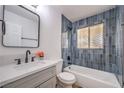 Bathroom with a combination tub and shower, modern fixtures, and updated tile surround at 1642 E St, Las Vegas, NV 89106