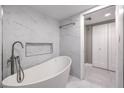 Modern bathroom featuring an oval tub, stylish fixtures, and white marble-patterned tile at 205 E Harmon Ave # 1007, Las Vegas, NV 89169